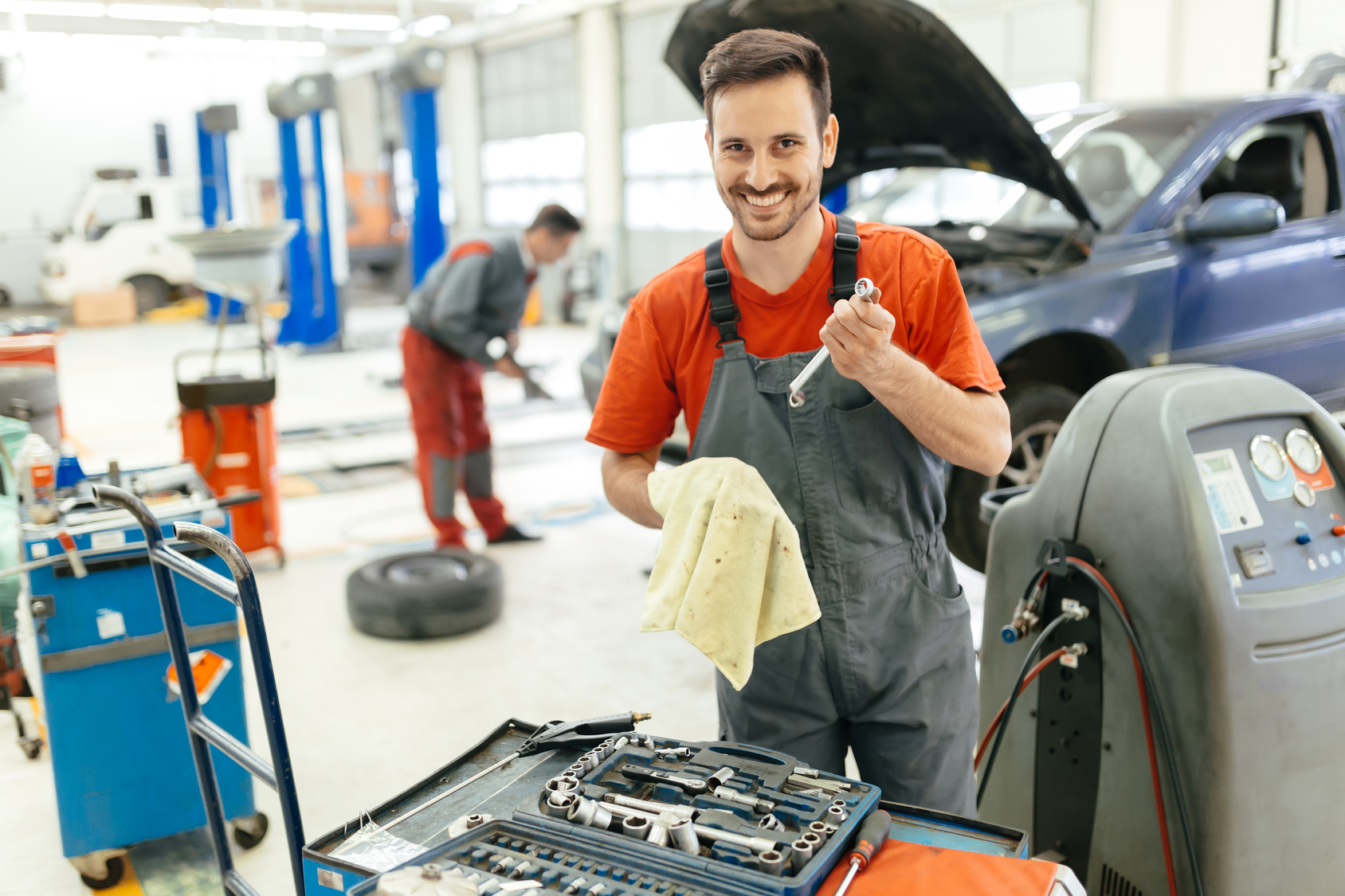 Car mechanic fixing a car in garage at dealership